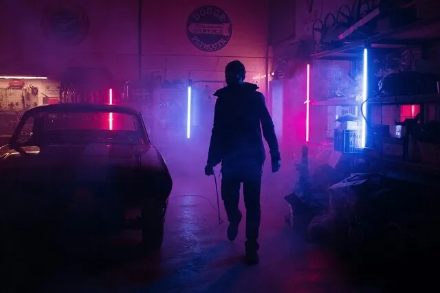 a person silhouetted by neon lights in a garage for are neon lights illegal in florida