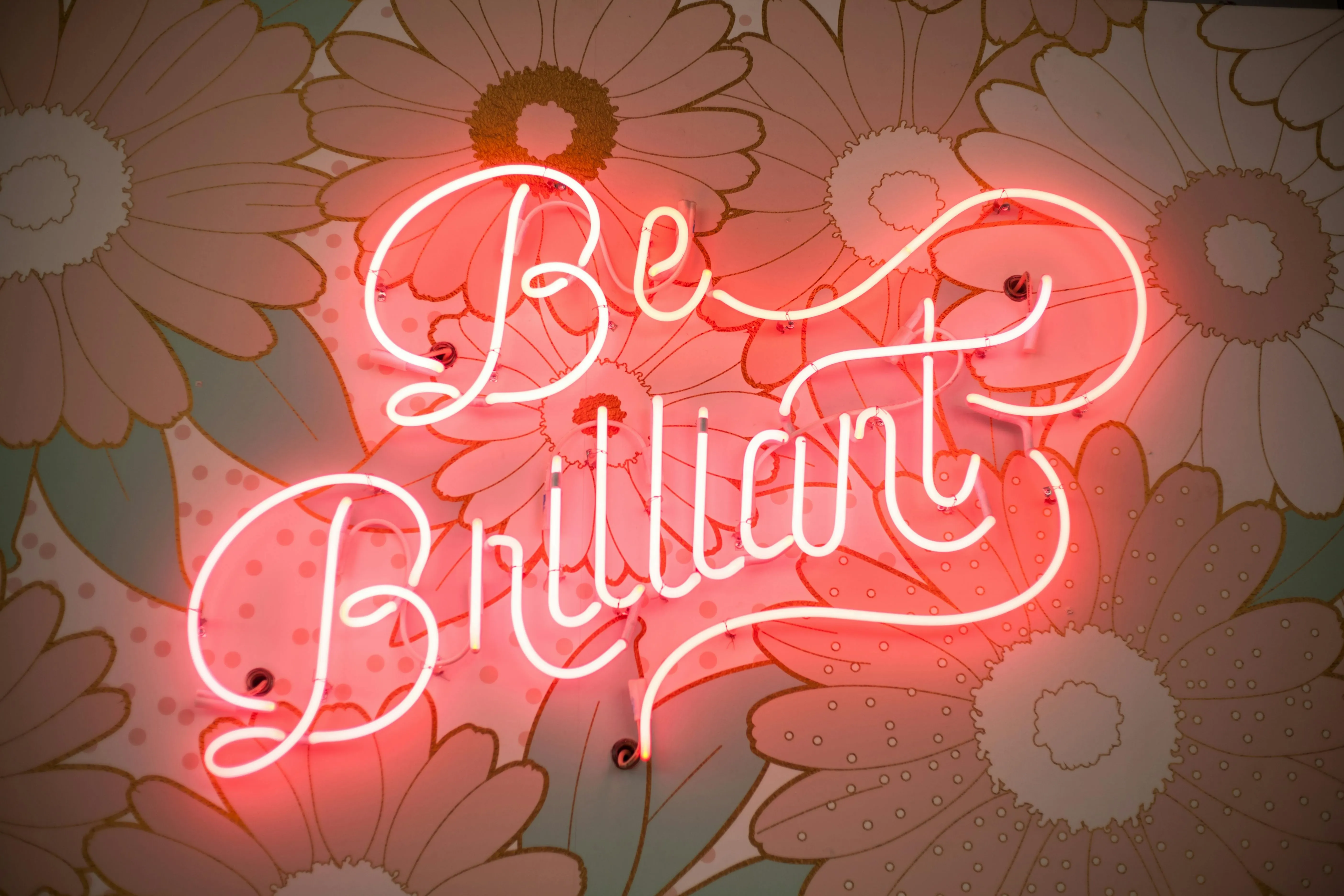 a red neon sign that reads be brilliant for gas in neon lights