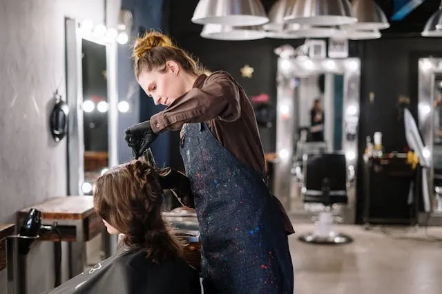 a woman getting a haircut for salon lighting ideas