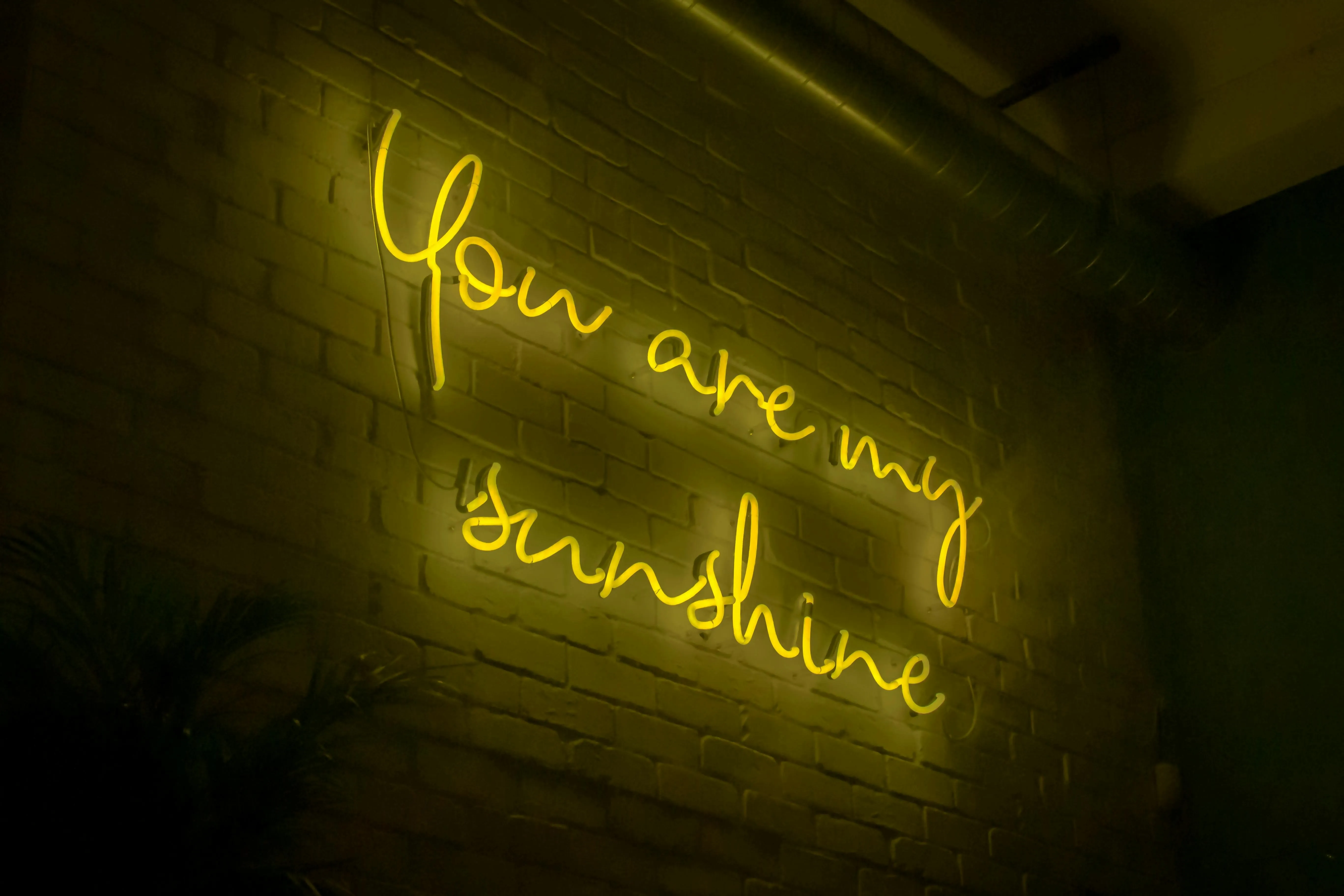 yellow neon sign on brick for how to hang neon sign on brick wall